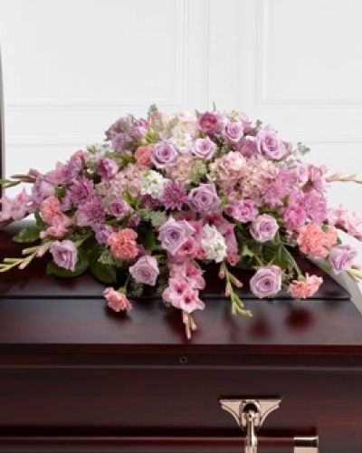 The FTD® Immorata™ Casket Spray offers soft beauty and blushing comfort to honor the life of the deceased. Lavender roses, chrysanthemums and parrot tulips are elegantly arranged amongst pink carnations, gladiolus, stock, hydrangea and lush greens to create a presentation, intended to bedeck the top of the casket, that evokes sweet memories of your loved one for their final farewell service.