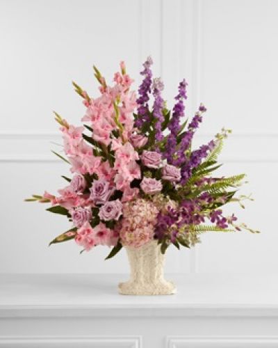 <p>The FTD® Flowing Garden™ Arrangement bursts with a bounty of blooms to create a stunning tribute of the deceased at their final farewell service. Lavender roses, pink gladiolus, purple dendrobium orchids, purple larkspur and pink hydrangea are accented with an assortment of lush, vibrant greens and perfectly arranged in a papier mache urn to create a presentation of grand beauty that symbolizes the life of the departed.</p>