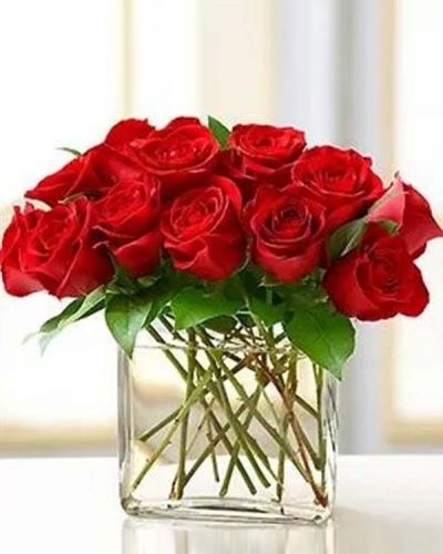 Surprise her with this modern spin on the traditional dozen roses. Stunning red roses are gathered in a chic rectangular glass vase and accented with a fashionable butterfly pick. Also available in pink, yellow and assorted.
