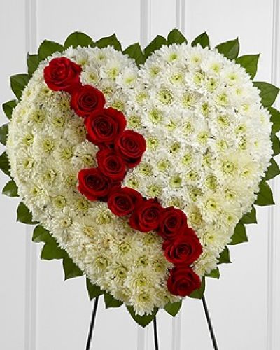 <p>The FTD® Broken Heart™ is a beautiful way to express the impact that the departed had on your life. Pearly white chrsyanthemums form the shape of a heart, accented with greens lined around the outside and "broken" in the middle with a line of rich red roses to create an exqusite way to honor the life of the deceased at their memorial service. Displayed on a wire easel.</p>