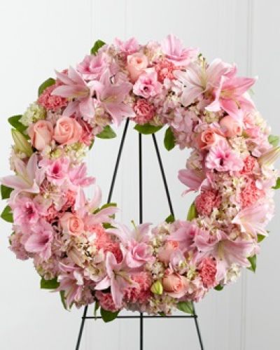 The FTD® Loving Remembrance™ Wreath is a blushing display of grace and beauty to honor the life of the deceased at their final tribute. Pink roses, Oriental lilies, gladiolus, hydrangea and carnations are brought together with lush greens to form the shape of a wreath, offering warmth and comfort with its sweetly sophisticated elegance. Displayed on a wire easel.