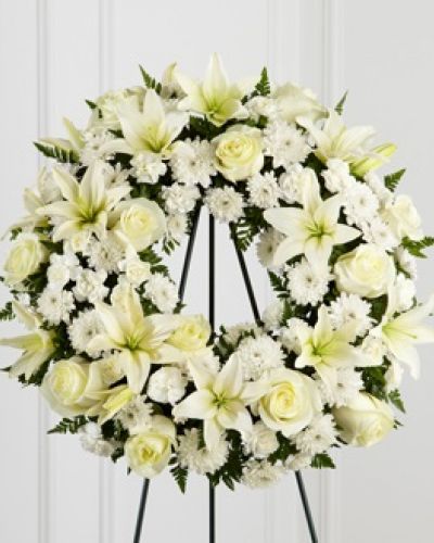 <p>The FTD® Treasured Tribute™ Wreath offers peaceful wishes of heartfelt sympathy with each delicate bloom. Bright white roses, Asiatic lilies, mini carnations and cushion poms are beautifully arranged to form an elegant accented with lush and vibrant greens. Displayed on a wire easel, this gorgeous tribute is a wonderful symbol of eternal life and sweet serenity.</p>