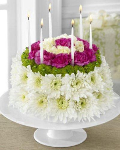 The Wonderful Wishes Floral Cake is set to celebrate their birthday with sweet sentiments blooming with chrysanthemums and carnations. Perfectly arranged in the shape and styling of a colorful birthday cake are white chrysanthemums, green button poms, pale yellow carnations and magenta mini carnations. Presented on a white cake plate, this memorable flower arrangement will add to the festivities of their special day.