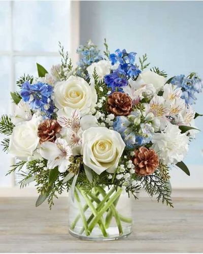<p>Inspired by winter’s cool blue & white landscape, our delightful arrangement delivers warm wishes to the people you love. Hand-designed with a lush gathering of blooms, evergreens and rustic touches, it’s a thoughtful sentiment filled with the season’s natural beauty.</p>
<ul>
<li>All-around arrangement with white roses, carnations and Peruvian lilies (alstroemeria); blue delphinium; accented with baby’s breath, seeded eucalyptus, assorted Christmas greenery and pinecones</li>
<li>Artistically designed in a clear glass cylinder vase</li>
<li>Large arrangement measures approximately 15"H x 13"W</li>
<li>Medium arrangement measures approximately 13"H x 12"W</li>
<li>Small arrangement measures approximately 12"H x 9"W</li>
<li>Our florists hand-design each arrangement, so colors, varieties and container may vary due to local availability</li>
<li>To ensure lasting beauty, Peruvian lilies may arrive in bud form and will fully bloom over the next few days</li>
</ul>