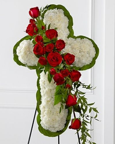 <p>The FTD® Floral Cross Easel is a symbol of love and faith to honor the deceased at the final farewell service. White carnations are arranged to form a cross in which an accent of red roses, spray roses, and lush greens are draped across the center, creating a beautiful display of serene elegance. Displayed on a wire easel.</p>
