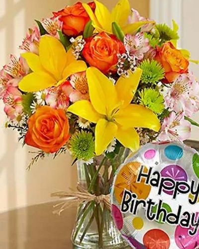 Get their party started with this elegant, hand-designed bouquet! Fresh roses, lilies, alstroemeria, poms and more are arranged by our florists inside a stylish clear glass vase tied with raffia as a nod to rustic European style. Paired with a festive 18" Mylar balloon, this is a perfect way to say "Happy Birthday!"