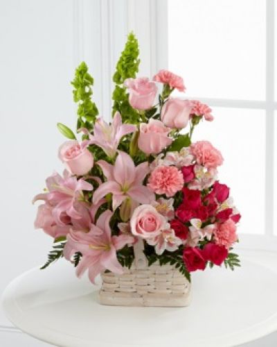 The FTD® Beautiful Spirit™ Arrangement is a light and lovely way to honor the life of the deceased. A blushing display of pink roses, Asiatic lilies and Peruvian lilies are highlighted by stems of fuchsia carnations and spray roses as well as Bells of Ireland and assorted lush greens. Seated in a white woodchip basket, this graceful arrangement creates an exceptional way to offer peace and sympathy.