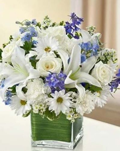 Send your best wishes with our blue and white Hope Floats arrangement. The freshest roses, delphinium, lilies, daisy poms and carnations are hand-designed in a stunning cube vase sure to wow and inspire your recipient.