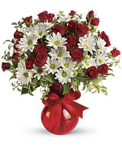 <p>Fly your colors! A festive red ribbon wraps up this sweet bouquet of red roses and white daisies. This loving gift is presented in our shapely red vase your special someone will adore all year long</p>