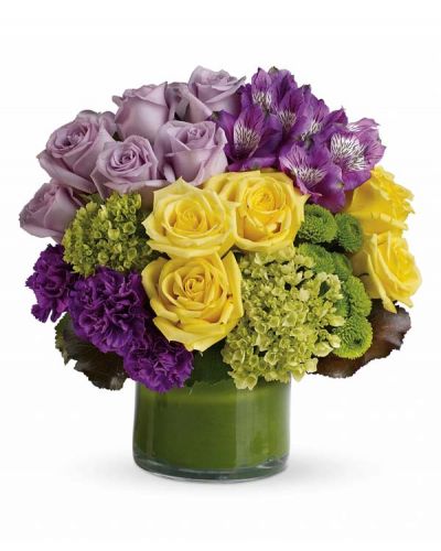 <p>This chic arrangement of Purple Perfection includes miniature green hydrangea, lavender and yellow roses, purple alstroemeria, dark purple carnations, green button spray chrysanthemums, galax leaves and a ti leaf delivered in a clear glass vase.</p>