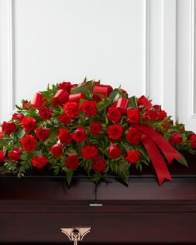 The FTD® Dearly Departed™ Casket Spray bursts with the love and passion that the deceased had for their life and loved ones. Rich red roses and carnations are gorgeously arranged amongst lush greens and accented with a red satin ribbon to create the ideal adornment for their casket at their final farewell service.