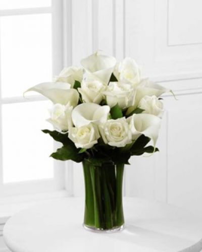 The FTD® Sweet Solace™ Bouquet is a divinely elegant arrangement that encourages peace and offers your sympathy. Brilliant white roses and calla lilies are simply set amongst lush greens in a clear glass gathering vase to create a meaningful gift that will help your special recipient through this trying time of grief and loss.