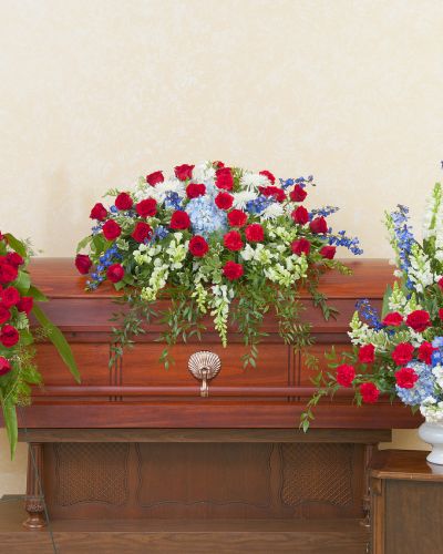 <p>A patriotic casket spray, standing spray, and urn in red, white and blue.</p>